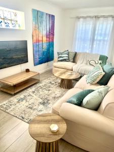 Blue Beach Haven في Cape Town: غرفة معيشة مع كنبتين وطاولتين +9 صور