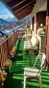 een balkon met stoelen en tafels en uitzicht op de bergen bij Maison Jacquemin in Saint-Pierre