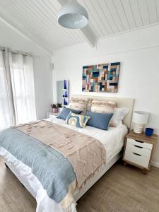 Blue Beach Haven في Cape Town: غرفة نوم بيضاء مع سرير كبير مع وسائد زرقاء