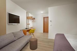 a living room with a couch and a tv at Hotel Hamar in Borgarnes