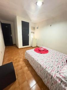 Un dormitorio con una cama con una cinta roja. en Quarto privado no centro 305, en Manaus
