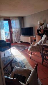 een woonkamer met een bank en een televisie bij Maison Jacquemin in Saint-Pierre