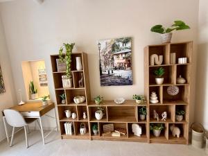 GudjaAS2 - The Alley Suites Apartment in Gudja的房间里有一张桌子和一个摆放着植物的书架。