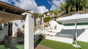 una casa blanca con un patio con sombrilla en Heated pool villa - El Acebuchal, en Acebuchal