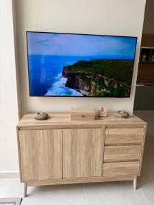 GudjaAS2 - The Alley Suites Apartment in Gudja的木质梳妆台上方的平面电视