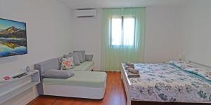 Un dormitorio pequeño con una cama y un sofá. en Castello, en Mali Lošinj