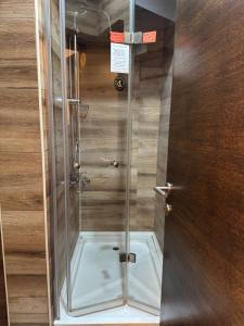 doccia con porta in vetro in camera di Pirocanac a Pirot Altre 30 foto