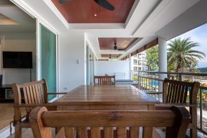 ein Esszimmer mit einem Holztisch und Stühlen in der Unterkunft Sea view apartment Bel Air Panwa by Lofty in Ban Makham