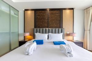 ein Schlafzimmer mit einem großen weißen Bett mit zwei Handtüchern in der Unterkunft Sea view apartment Bel Air Panwa by Lofty in Ban Makham + 33 Fotos