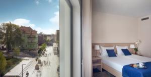 a bedroom with a bed and a view of a city at Hotel Molo in Sopot +34 photos