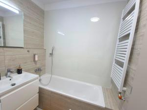 a bathroom with a white tub and a sink at Apartmán 103 in Spišská Nová Ves +18 photos