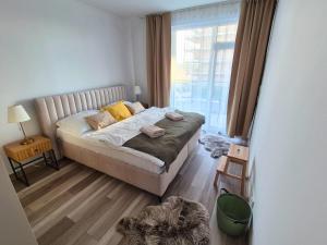 a small bedroom with a bed and a window at Apartmán 103 in Spišská Nová Ves