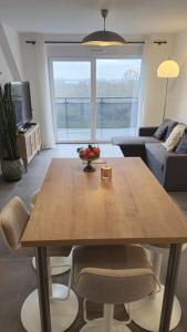 a wooden table in a living room with a couch at Logement entier appartement Bischoffsheim in Bischoffsheim