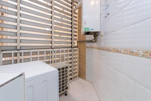 a bathroom with white tile walls and a washer and dryer at APARTAMENTO EN MADRID CENTRO comodo in Madrid +13 photos