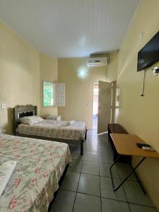 a hotel room with two beds and a desk at Pousada Sitio Preguicas in Barreirinhas +71 photos