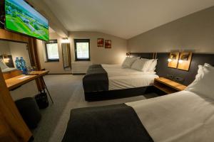 a hotel room with two beds and a flat screen tv at Villa Veranda in Smolyan