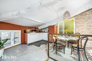 Maison de Caractère - Au cœur de Lourmarin في لورمارين: مطبخ وغرفة طعام مع طاولة وكراسي