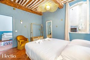 Maison de Caractère - Au cœur de Lourmarin في لورمارين: غرفة نوم بها سرير أبيض كبير وكرسي