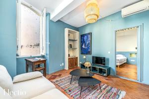 Maison de Caractère - Au cœur de Lourmarin في لورمارين: غرفة معيشة زرقاء مع أريكة وطاولة