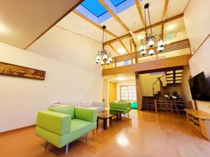 a living room with green chairs and a couch at Yunokawa Onsen KOMOREBISO in Hakodate