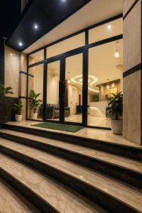 a lobby with large windows and potted plants at Four Season Vrindavan # Near Prem Mandir # Luxury Rooms # Prime Location # Property Of The Year # By chandrodaya orchid # in Vrindāvan