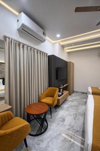 a hotel room with a bed and a table and chairs at Four Season Vrindavan # Near Prem Mandir # Luxury Rooms # Prime Location # Property Of The Year # By chandrodaya orchid # in Vrindāvan