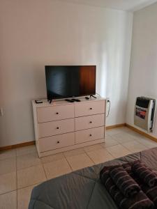 a tv sitting on top of a dresser in a room at Casa centro in Tolhuin