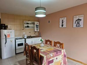 a kitchen with a table and a white refrigerator at Casa centro in Tolhuin