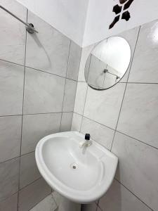 un bagno con un lavandino bianco e uno specchio di Quarto privado no centro 203 a Manaus Altre 4 foto