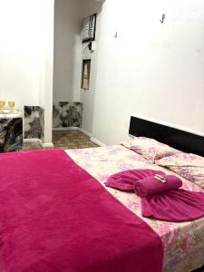 una camera con un letto rosa con due cuscini sopra di Quarto privado no centro 203 a Manaus