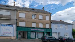 a building on a street with cars parked in front at Le Perchoir du marché - Appartement pour 2 personnes in Saint-Nazaire