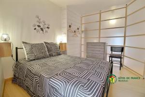 a bedroom with a large bed and a chair at Maison de la vilaine in Saint-Dolay