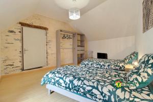 a bedroom with a bed and a large window at Maison de la vilaine in Saint-Dolay