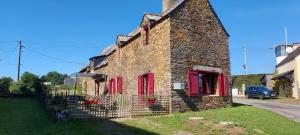 an old stone house with red windows and a fence at Maison de la vilaine in Saint-Dolay +9 photos