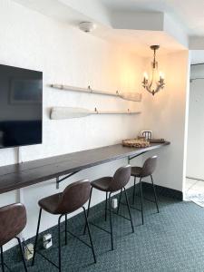 een kamer met een tafel met vier stoelen en een televisie bij Beach Access Elegant Studio near Top Attractions in Ortona