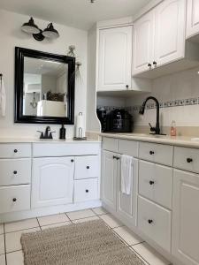 een witte keuken met een wastafel en een spiegel bij Beach Access Elegant Studio near Top Attractions in Ortona +23 foto's