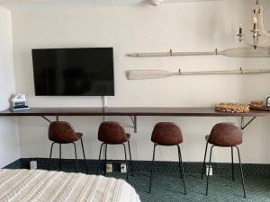 a bedroom with two chairs and a table with a television at Beach Access Elegant Studio near Top Attractions in Daytona Beach