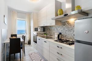 a kitchen with white cabinets and a table and a refrigerator at A casa di Alida in Cotulo