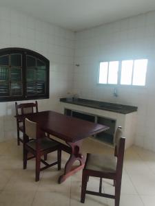 una cucina con un tavolo e sedie in legno in una stanza di Paradise a Saquarema Altre 12 foto