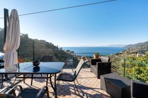 a balcony with a table and chairs and the ocean at A casa di Alida in Cotulo