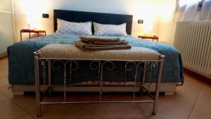 a bed with a blue comforter and towels on it at Casetta Lisa in Campegine