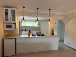 Una cocina con gabinetes blancos y encimera. en 48 Cintsa Bay, en Cintsa West