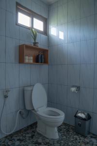 ein Bad mit einem weißen WC und einem Fenster in der Unterkunft Pakel's Bali Villas in Amed + 54 Fotos