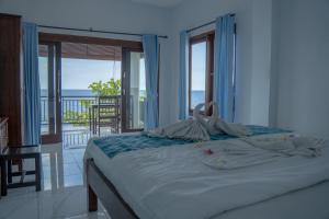 ein Schlafzimmer mit einem Bett mit Blick auf das Meer in der Unterkunft Pakel's Bali Villas in Amed