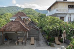 eine Gruppe von Gebäuden mit Bänken vor einem Gebäude in der Unterkunft Pakel's Bali Villas in Amed