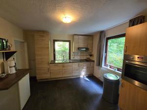 una grande cucina con armadi in legno e una finestra di Ferienhaus Lemmerwald a Neerdar