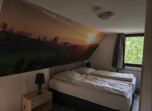 una camera da letto con un letto e un quadro sul muro di Ferienhaus Lemmerwald a Neerdar