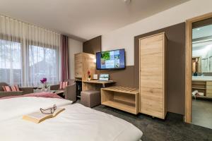 pokój hotelowy z łóżkiem i telewizorem w obiekcie Hotel Schloßberg w mieście Gräfenberg