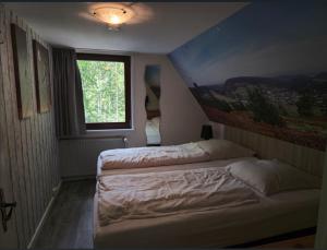 due letti in una piccola stanza con una finestra di Ferienhaus Lemmerwald a Neerdar