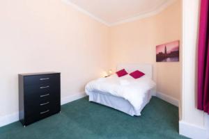 a bedroom with a bed and a dresser in it at Gazeley Manor House - Central Huntingdon in Huntingdon